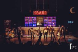 hombres cantando en un escenario 